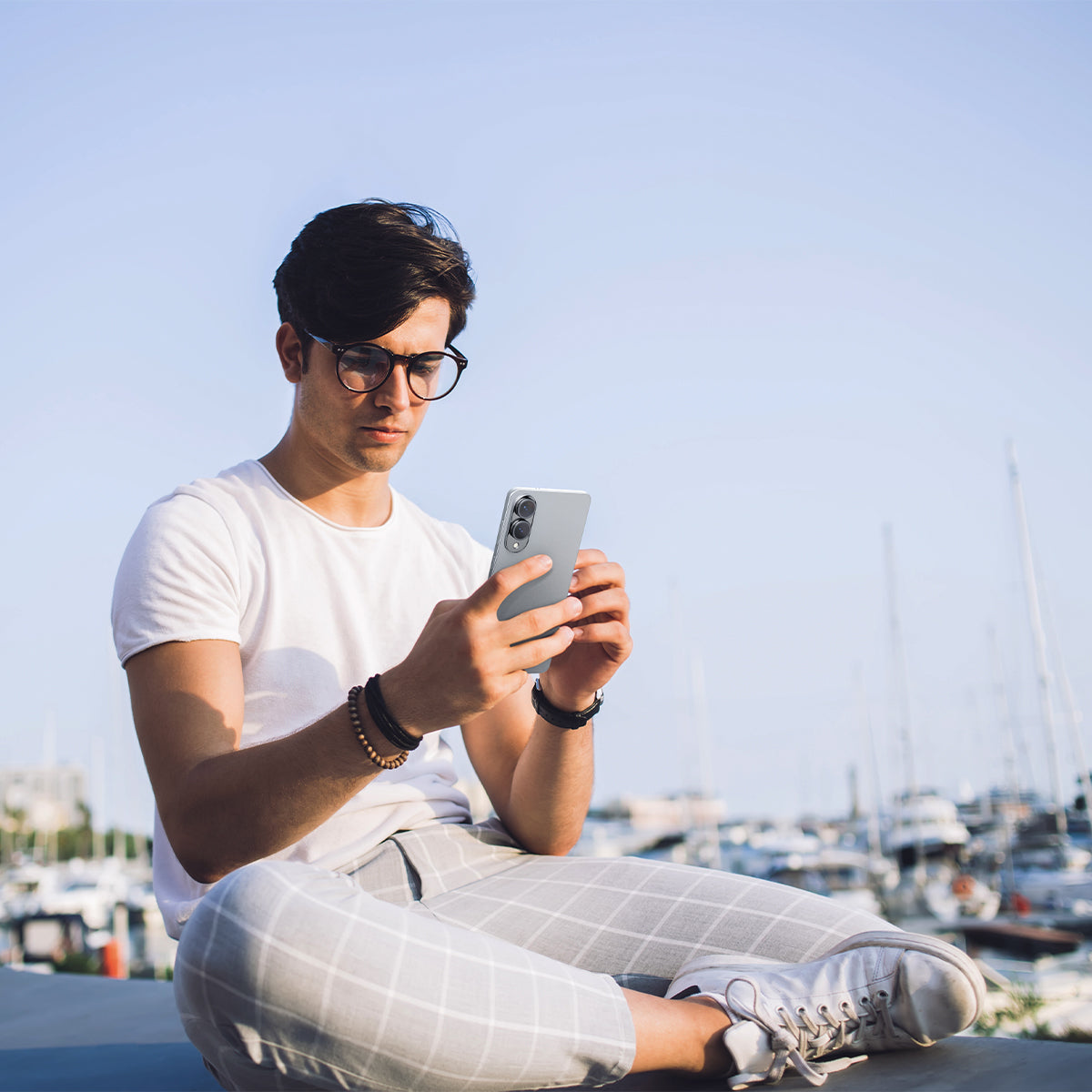 AGL09412 - Galaxy S25 Edge Optik EZ Fit Lens Pro Protector in Black showing the a man holding the device with the lens screen protector installed