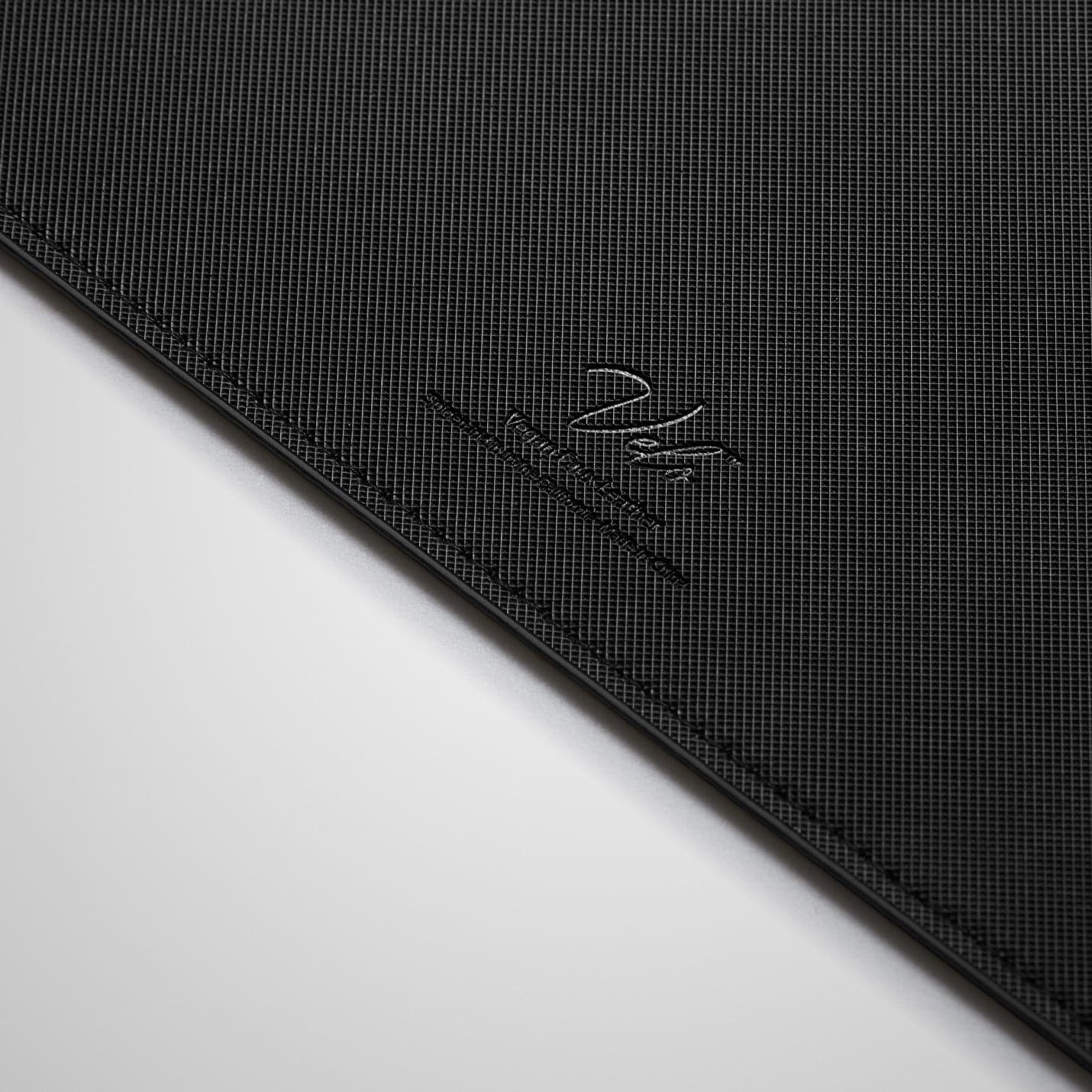 APP04762 - LD302 Desk Pad in black showing the back zoomed in on the vegan leather logo