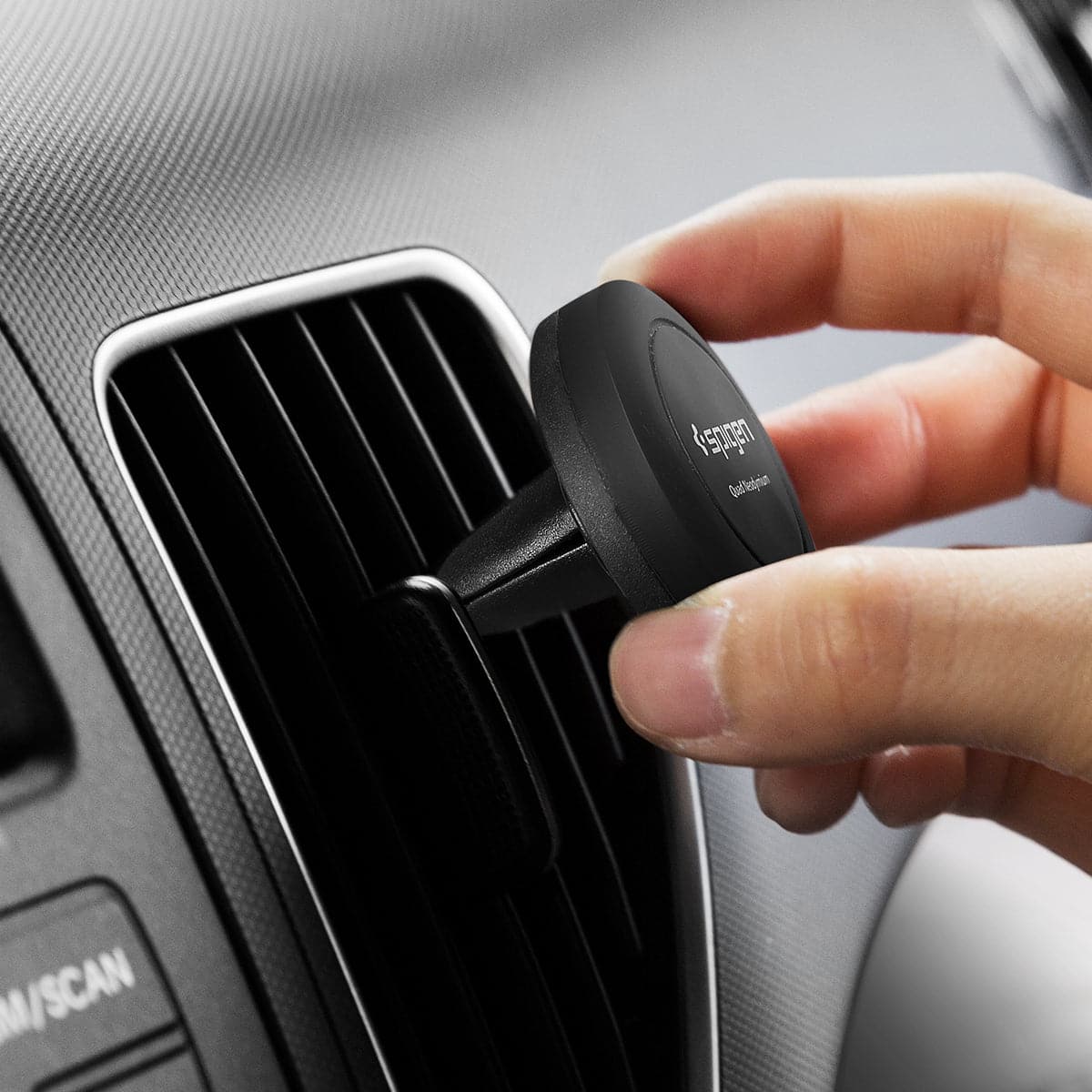 SGP11583 - Spigen Kuel Q11 Magnetic Air Vent Car Mount showing a hand placing car mount into airvent